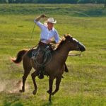 Drew Waters riding a horse with lasso