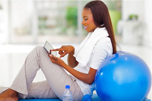 woman exercising with online personal training tablet
