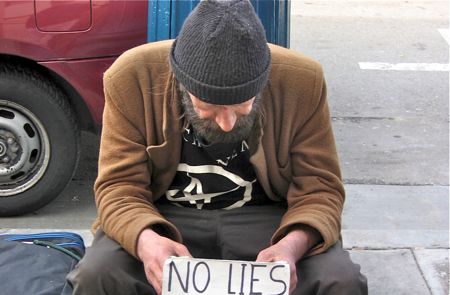 Homeless man holding sign.