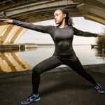 woman stretching under bridge