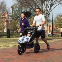 couple running with child in stroller