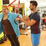 woman doing TRX with trainer