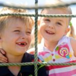 children climbing on a playground net