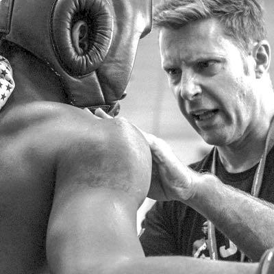 Close up of a strength coach talking to a boxer and motivating him.