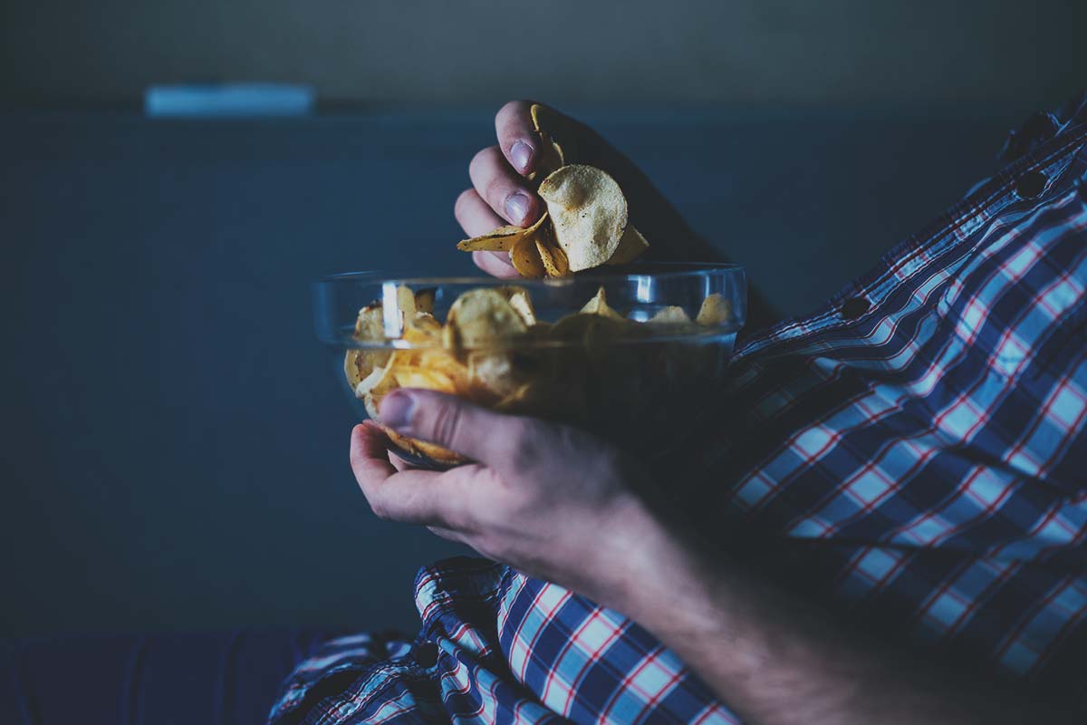 dad eating chips on couch